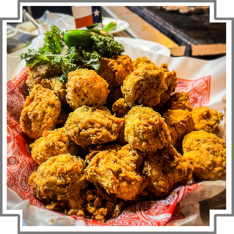 Fried mushrooms on a red and white paper with a Texas flag in the background