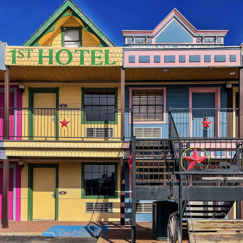 Colorful '1st Hotel' building with star decorations against a blue sky.