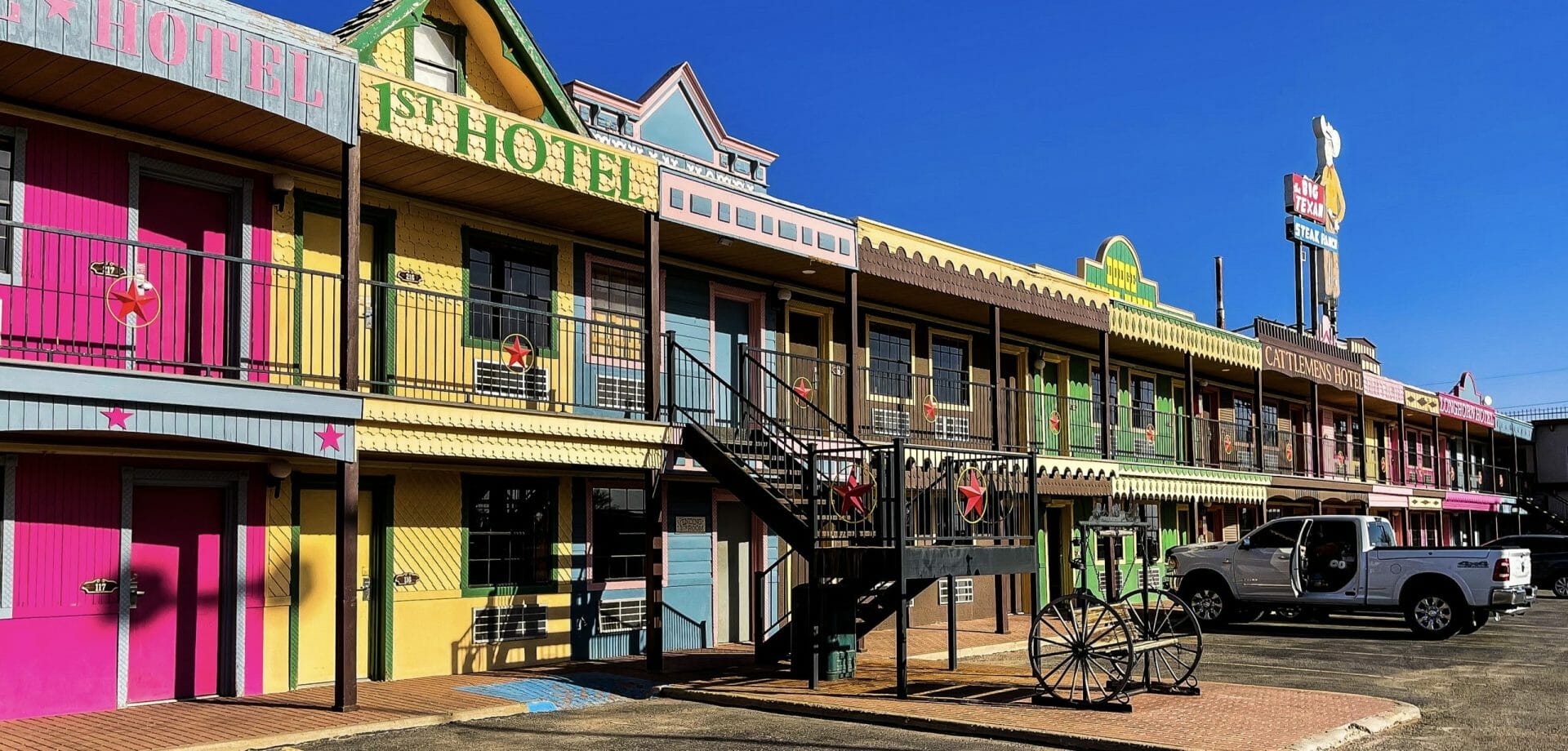 Colorful hotel facade with '1st Hotel' sign on a clear day