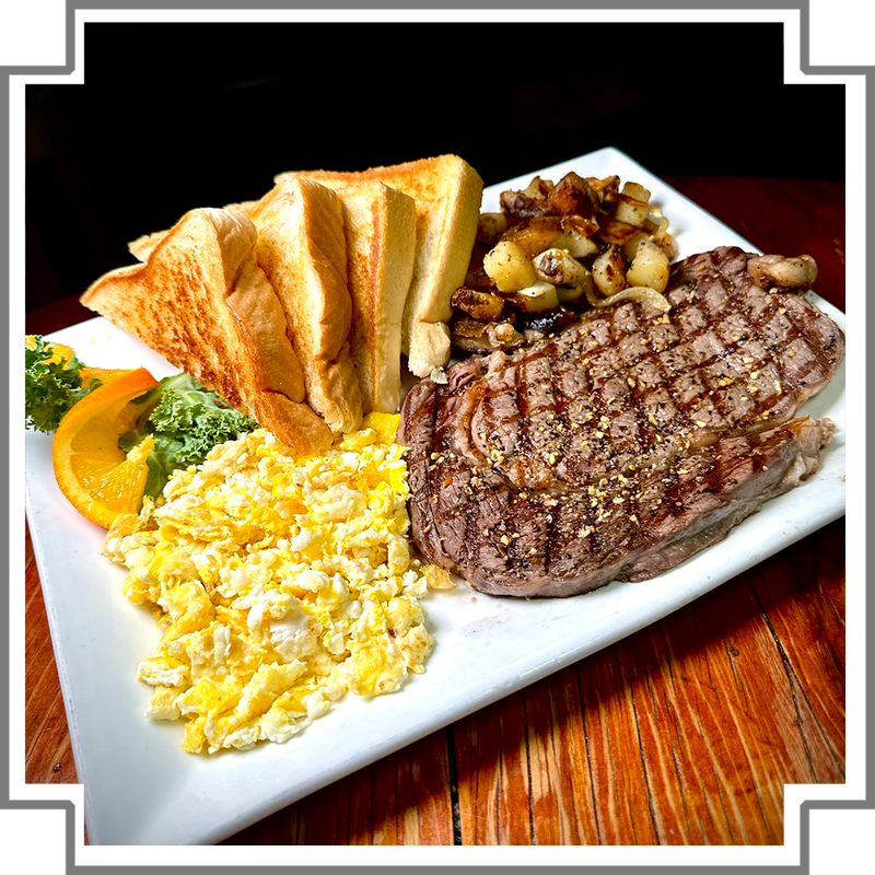 Steak with scrambled eggs, toast, and vegetables on a white plate.