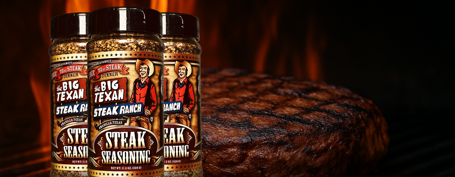 Three bottles of Big Texan Steak Ranch seasoning with a grilled steak in the background.