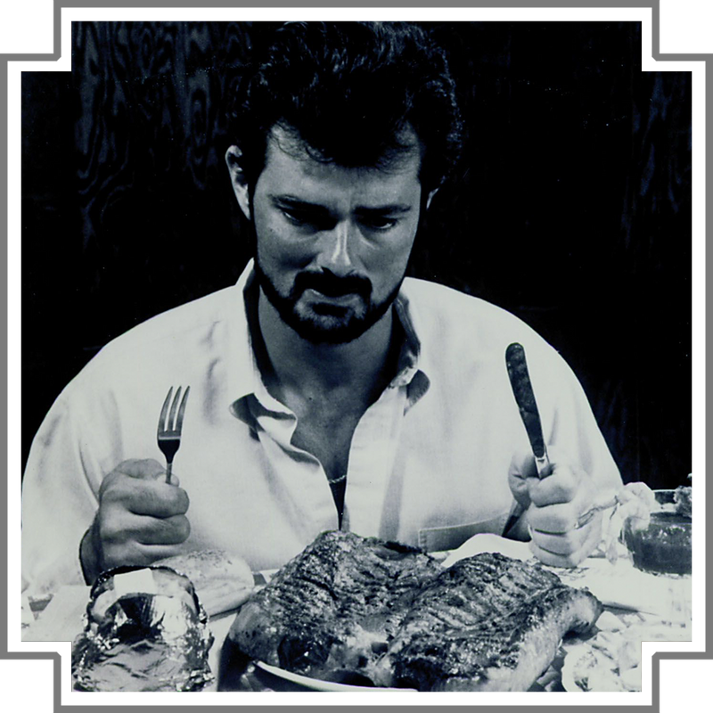 Man sitting at a table with a large steak in front of him, holding a fork and knife.
