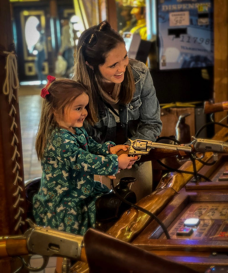 Woman and child playing with toy guns in a store setting