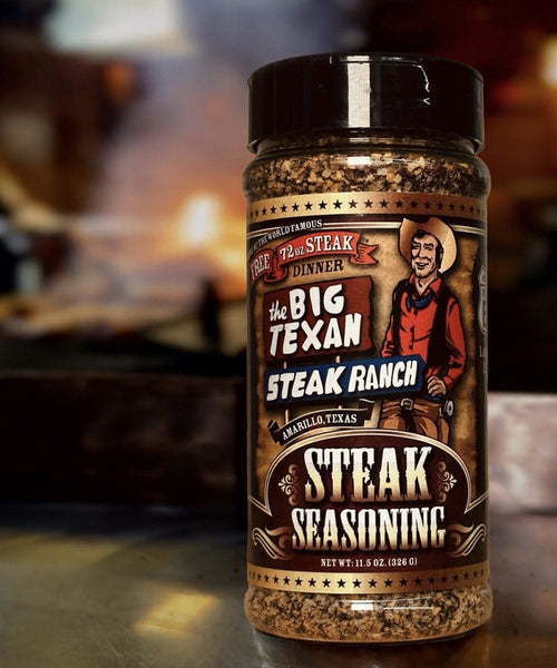Plastic jar of Big Texan Steak Ranch steak seasoning with a blurred background