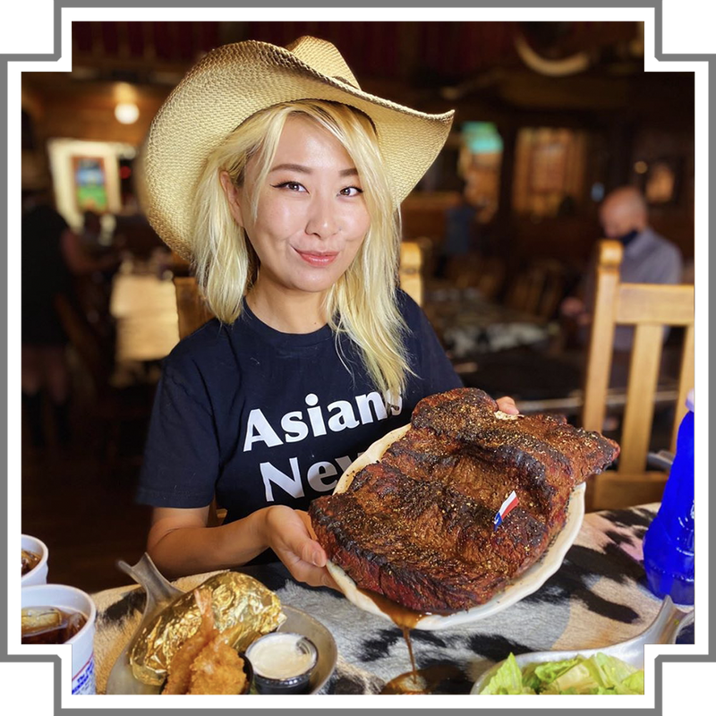 Person wearing a cowboy hat holding a large steak in a in the big texan dining room