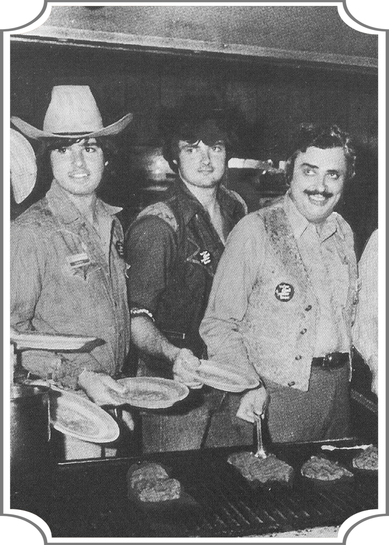 Three men in cowboy attire cooking on a grill, with a framed border.