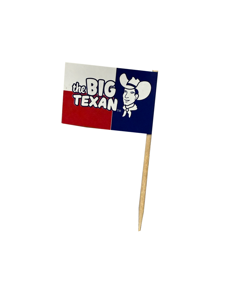 Small toothpick with flag on the top of it featuring 'the Big Texan' and smiling cowboy head