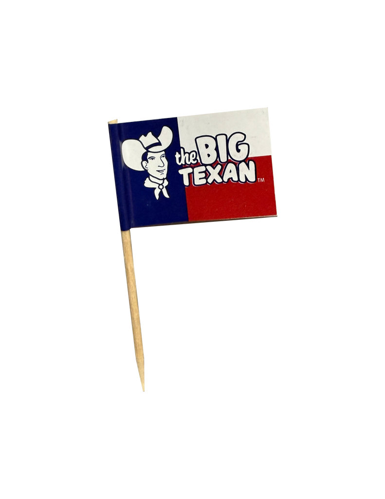 Small toothpick with flag on the top of it featuring 'the Big Texan' and smiling cowboy head