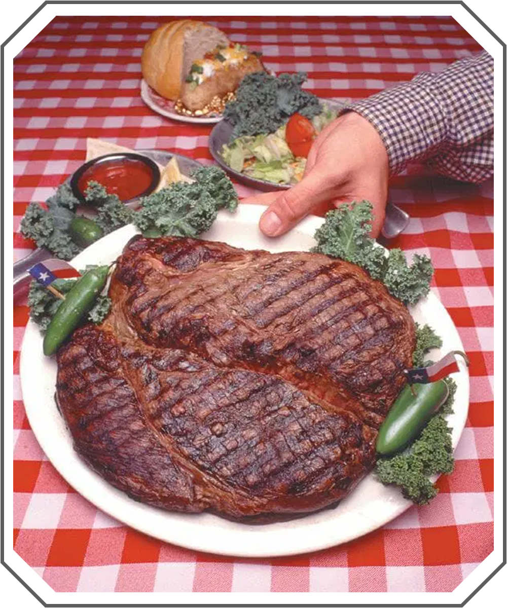 the 72oz steak on a plate with side dishes on a red and white checkered tablecloth.